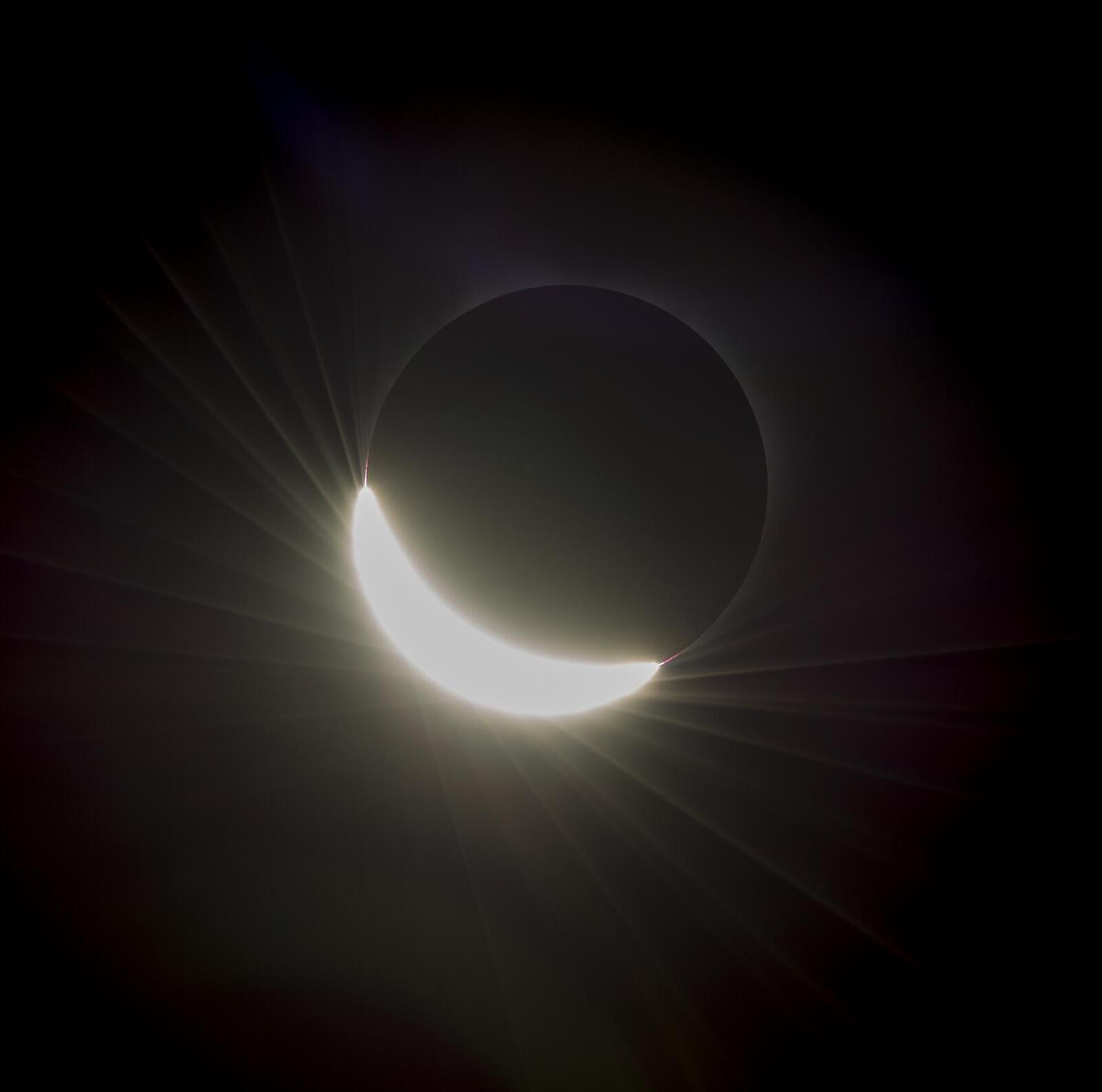 2 or 3 different pictures of the eclipse showing different stages of shadow. In each of the images parts of the Sun’s corona are visible. 